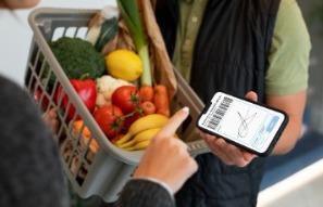 Persona comprando sus verdura en el supermercado mostrado su firma electrónica desde el celular